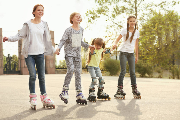 Teenager girls on roller skates in park - Фото, изображение