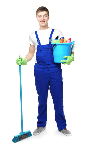 Young man holding cleaning equipment and supplies on white background - Zdjęcie, obraz