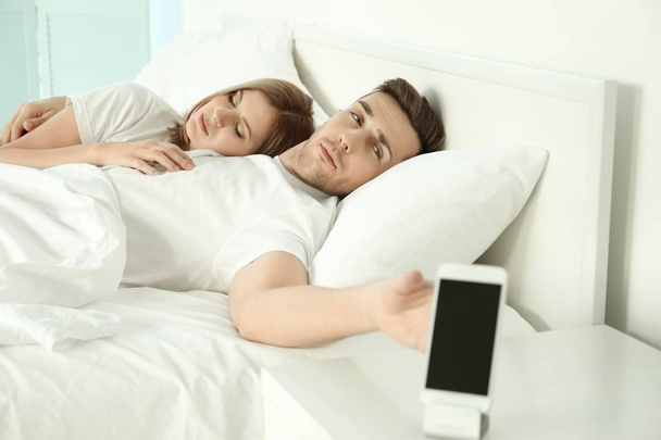 couple waking up with alarm clock - Zdjęcie, obraz