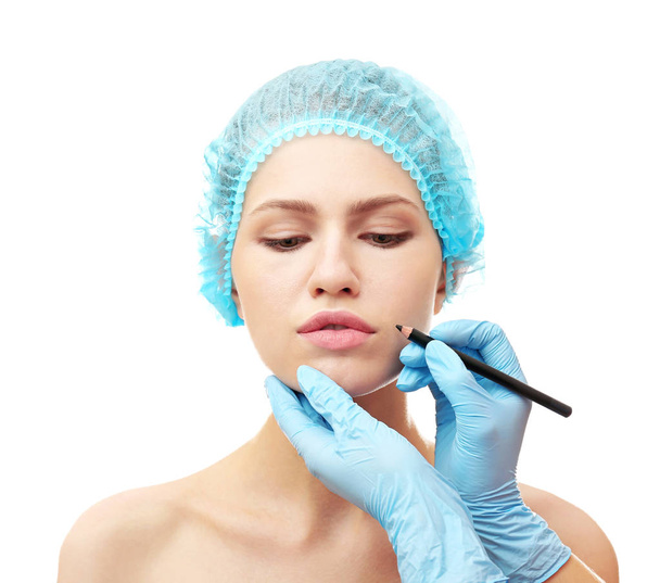 Plastic surgeon drawing line on face - Foto, imagen