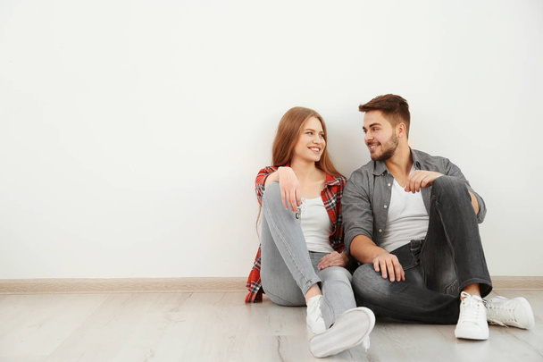 Happy young couple sitting on floor  - Foto, Imagem