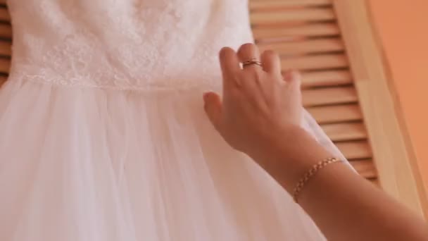 Zblízka Zenske ruky na bílé svatební šaty. Před svatební obřad. Nevěsta - Záběry, video