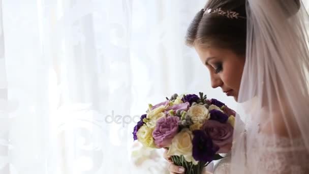 Krásná nevěsta v luxusních svatebních šatech vonící kytice. Detailní záběr - Záběry, video