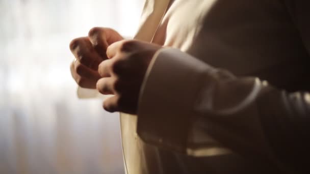 Groom buttoning up his white shirt before wedding ceremony. Close up. Soft light - Footage, Video