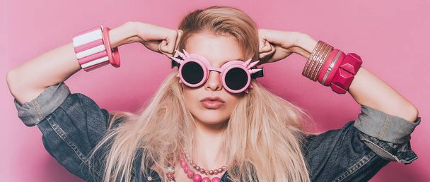 Портрет поп-дівчини в непарних сонцезахисних окулярах і позуючій коробці
 - Фото, зображення