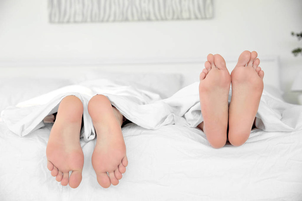 Feet of couple in bed - Foto, afbeelding