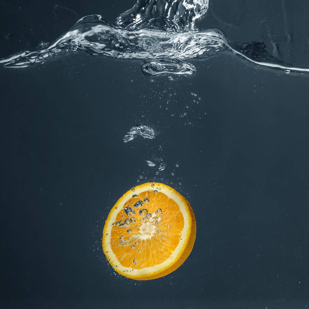 juicy orange falling in water - Фото, изображение
