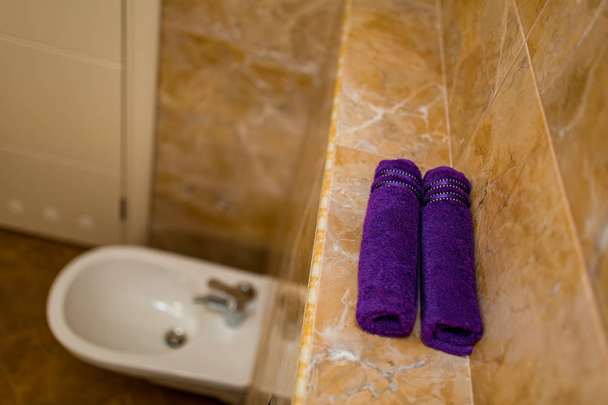 Asciugamani viola in bagno in rotoli
 - Foto, immagini