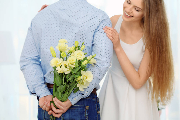 man hiding flowers for girlfriend - Photo, image