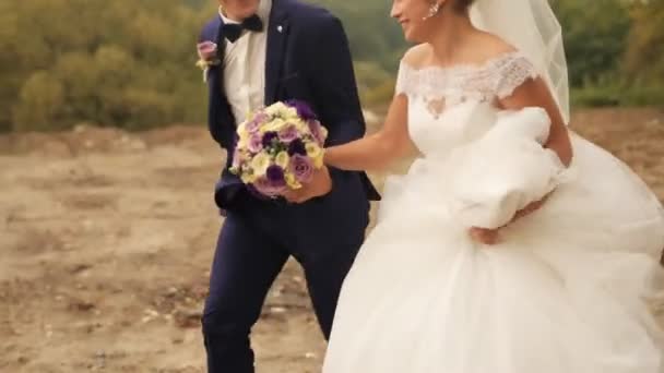 Bräutigam und Braut laufen an einem Sommertag im Park. Hochzeitspaar. Außenschuss - Filmmaterial, Video