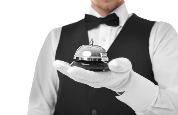 Young waiter with service bell on white background - Φωτογραφία, εικόνα