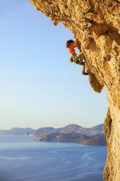 Escaladora femenina en ruta desafiante en acantilado
 - Foto, imagen