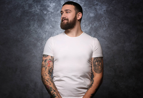 Portrait of tattooed man on gray background - Foto, immagini