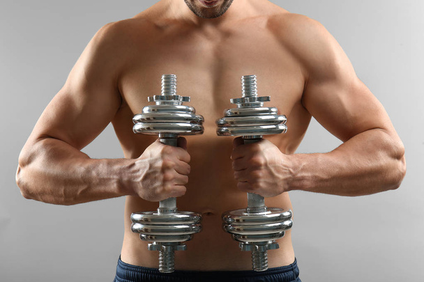 Sporty man doing exercises with dumbbells  - Photo, Image