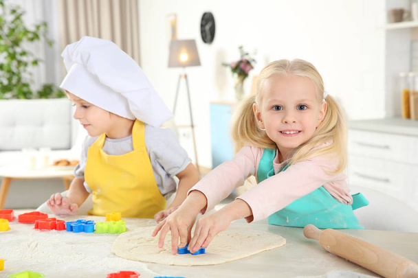 Little kids making biscuits on table - Photo, image