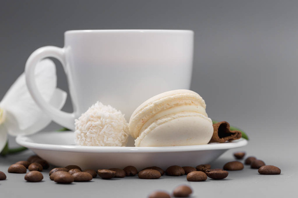 Λευκό φλιτζάνι καφέ, με καραμέλα σε ένα γκρίζο φόντο - Φωτογραφία, εικόνα