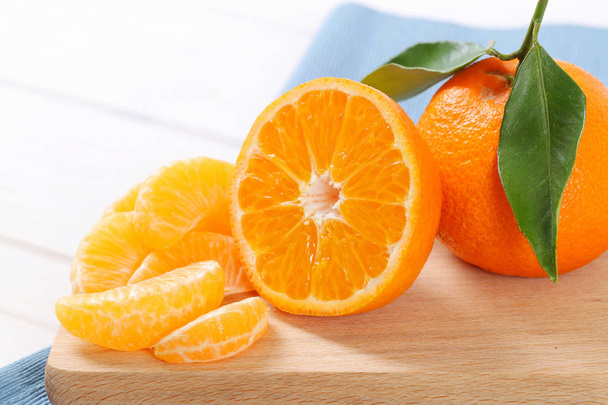 Ganze und in Scheiben geschnittene Mandarinen - Foto, Bild