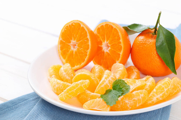 Egész és szeletelt mandarin - Fotó, kép