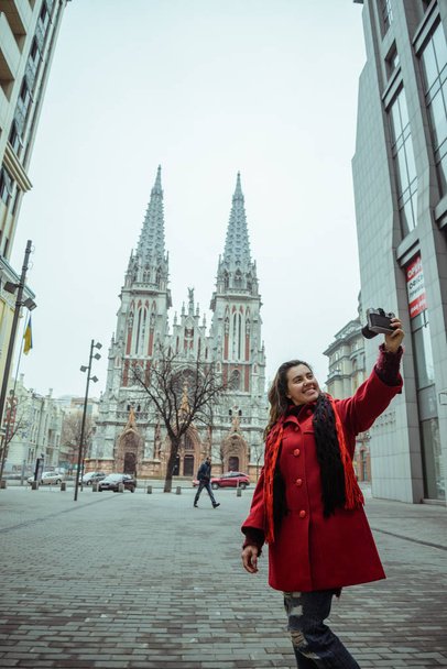 young pretty woman take selfie in front of gothic church - Фото, зображення