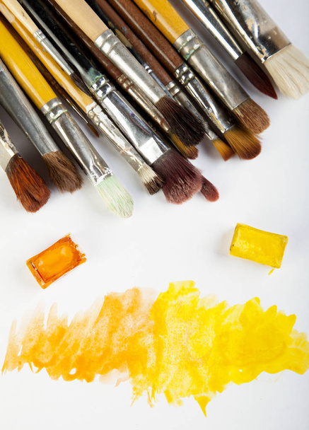 Paint Orange Yellow Brushes and white blank paper top view  - Photo, Image
