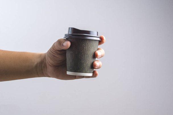 Χέρι που κρατά το φλιτζάνι ζεστό καφέ - Φωτογραφία, εικόνα