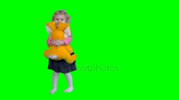 niedliches kleines Mädchen tanzt mit ihrem großen besten Freund Hasen isoliert auf grün - Filmmaterial, Video