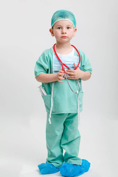 Full length portrait of cute smiling boy playing a doctor. Different occupations. Isolated over white. - Photo, Image