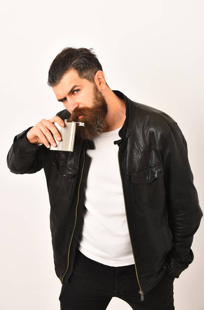 serious bearded man hipster with metallic jar in leather jacket - Fotó, kép