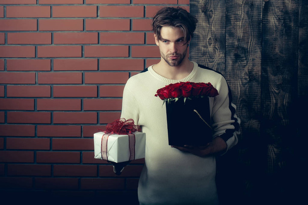 bearded man holds red rose flowers and present box - Foto, Imagem