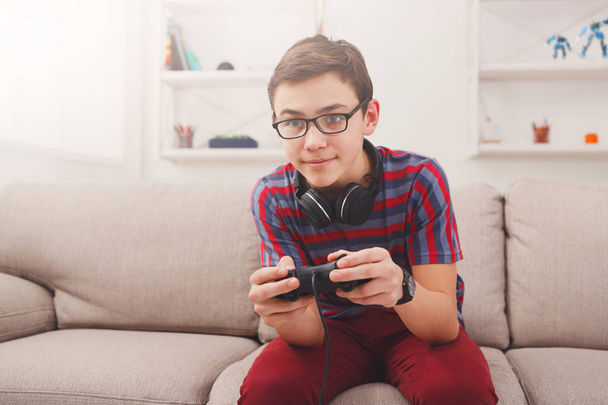 Возбужденный подросток, играющий в видеоигры дома
 - Фото, изображение