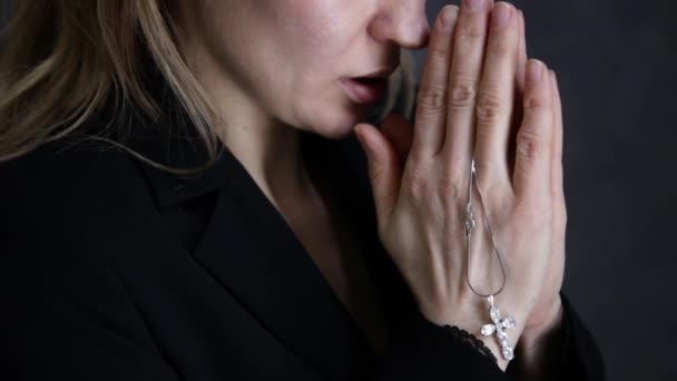 young woman is praying. close-up female hands holding chain with a cross - Materiaali, video