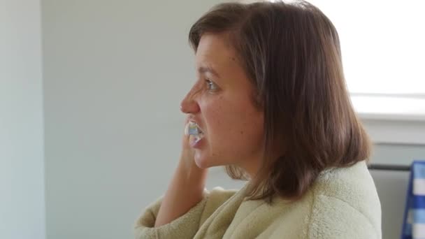 woman brushing her teeth in robe - Felvétel, videó