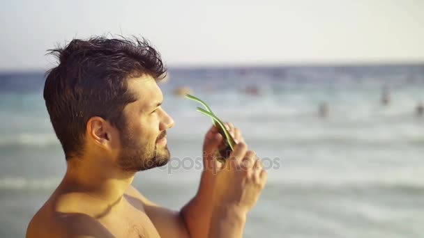 Європейські спортивні чоловік любить подання сонця і моря, Надівши сонцезахисні окуляри, на тлі моря і хвиль. Повільний рух - Кадри, відео