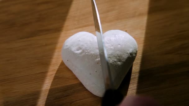 Nóż tnie białe ciasteczka w kształcie serca na dwie połówki - Materiał filmowy, wideo