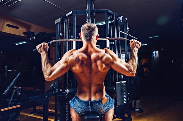 Strong Bodybuilder Doing Heavy Weight Exercise For Back On Machine - Foto, Imagen