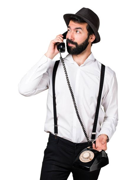 Hipster man with beard talking to vintage phone - 写真・画像