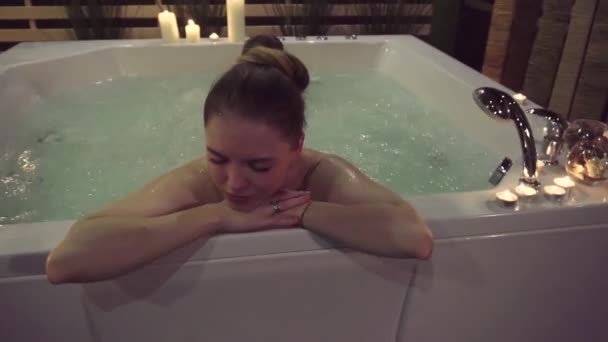 A pretty woman enjoys silence and loneliness in a jacuzzi with aromatic oils. - Footage, Video