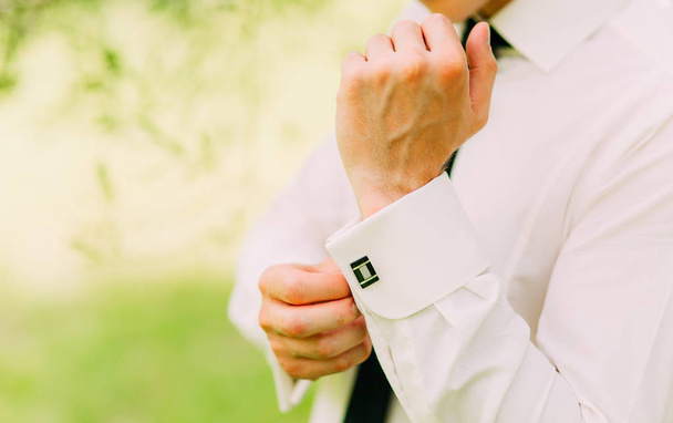 Buttoning cuffs. The groom wears cufflinks. Businessman inserts - Fotografie, Obrázek