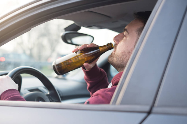 Μεθυσμένος άντρας οδήγηση του αυτοκινήτου και την κατανάλωση - Φωτογραφία, εικόνα