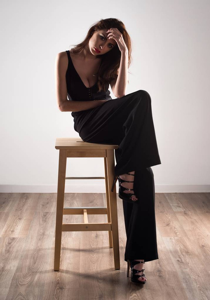 Beautiful model woman sitting on wooden chair - Fotoğraf, Görsel