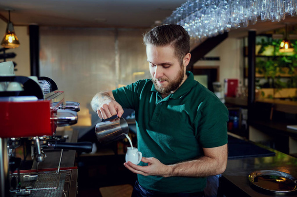 The bartender barista pours  hot milk into a glass in  bar cafe - Fotografie, Obrázek