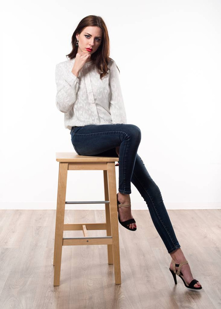 Beautiful model woman sitting on wooden chair - Foto, Imagen