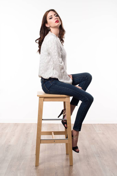 木製の椅子の上に座って美しいモデルの女性 - 写真・画像