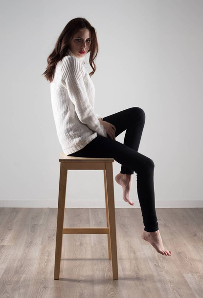 Beautiful model woman sitting on wooden chair - Foto, Imagen