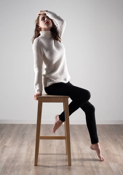 木製の椅子の上に座って美しいモデルの女性 - 写真・画像