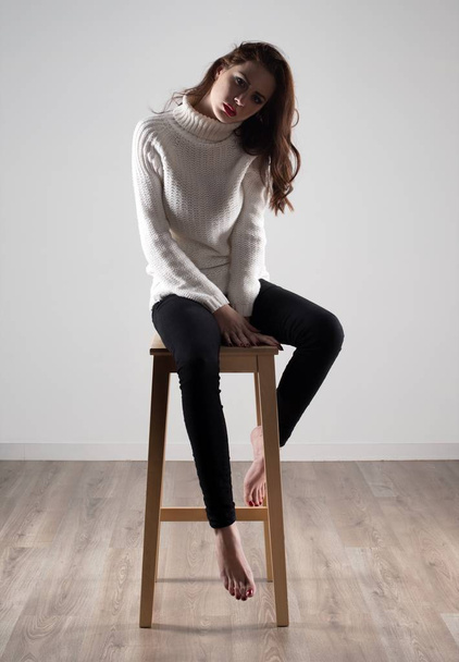 Beautiful model woman sitting on wooden chair - Foto, Bild