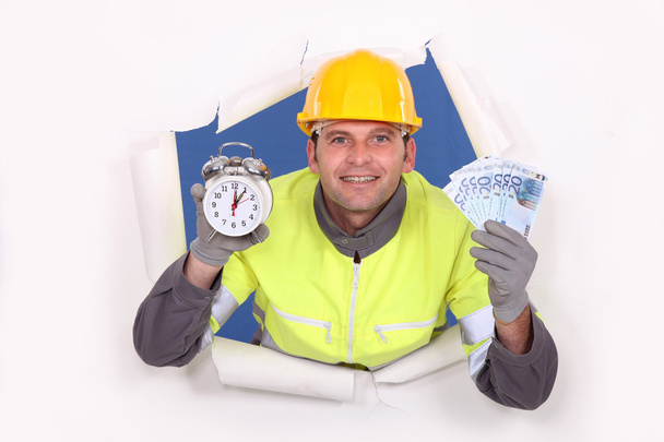 Laborer holding bills and alarm clock - Foto, Bild