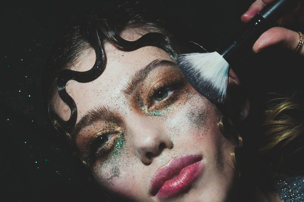 Pretty fashion girl putting holiday glitter makeup - Fotoğraf, Görsel