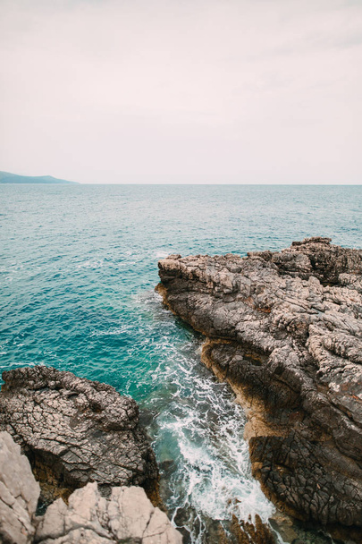 Rocks on the sea in Montenegro. Rocky coast. Wild beach. Dangero - Photo, Image