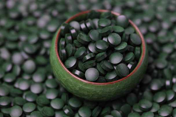 pilules de spiruline dans un bol vert
 - Photo, image